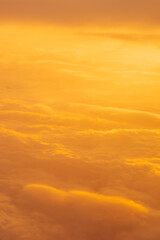 landscape on yellow sunset sky with clouds from airplane window