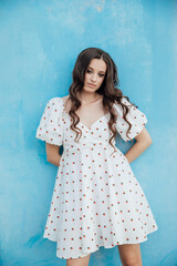slim fashion brunette woman in summer white dress on blue background