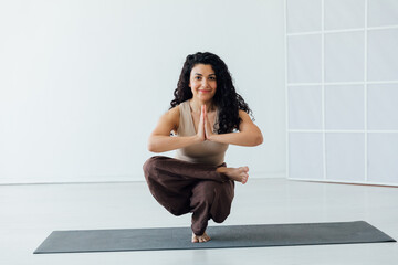 woman doing gymnastics yoga asana on the floor in the hall