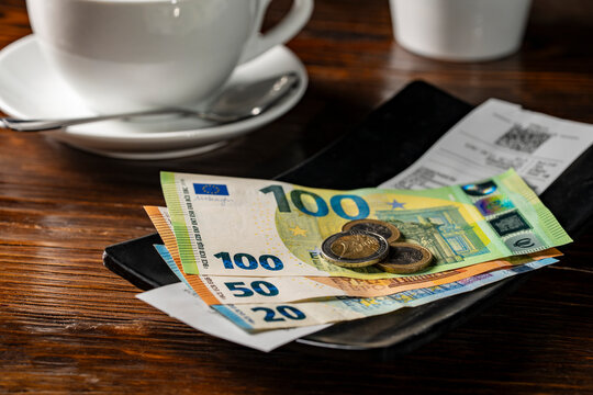 European money in a tip tray when paying a bill after eating at a restaurant, closeup. Paying for your bill tab at a restaurant cafe with cash euro money