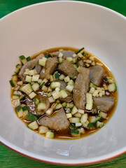 a bowl of empek-empek food on a green table