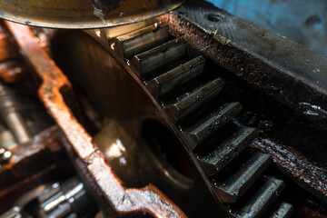 repair of an old blue tractor in a vintage garage, dismantling and installation of a gearbox, replacement of bearings