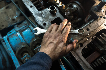repair of an old blue tractor in a vintage garage, dismantling and installation of a gearbox,...