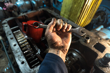 repair of an old blue tractor in a vintage garage, dismantling and installation of a gearbox,...