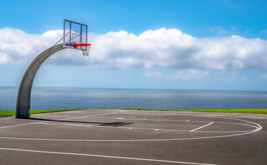 Outdoor basketball court with amazing ocean view and dramatic sky
