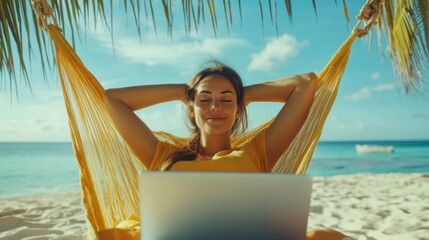 Young inspired nomad woman with hands behind head relaxing in a hammock and enjoying calm working remotely at the laptop at seashore, dream job at anywhere in the world