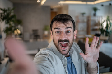 Obraz premium Enthusiastic man making a video call from home