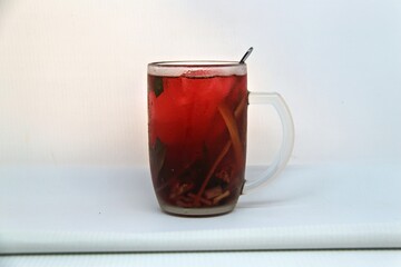 Chilled version of Wedang Uwuh, a traditional Indonesian herbal drink made with ginger, cinnamon, cloves, and lemongrass. Served cold with a vibrant red color and refreshing taste.