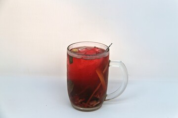 Chilled version of Wedang Uwuh, a traditional Indonesian herbal drink made with ginger, cinnamon, cloves, and lemongrass. Served cold with a vibrant red color and refreshing taste.