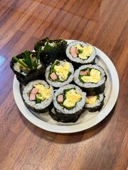 Delicious kimbap rolls filled with fresh vegetables, seasoned rice, and savory proteins, all wrapped in crisp seaweed. A perfect combination of flavor and texture in every bite.