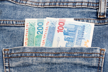 Iranian Rial in the pocket of blue jeans