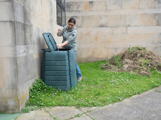 Fototapeta premium Woman using aerator in compost bin for organic waste recycling