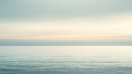 Obraz premium A serene ocean view with gentle waves and soft pastel colors in the sky, creating a tranquil and calming atmosphere.