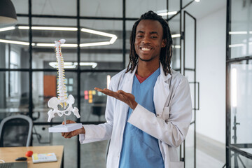 Man doctor is showing the model of human spine