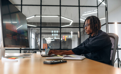 Working by using laptop. Designer is in the office