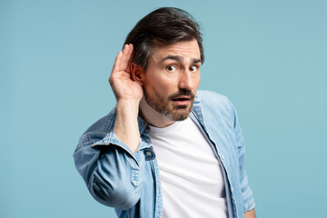 Curious man overhearing interesting conversation holding hand to ear