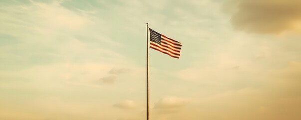 American Flag on Tall Pole Against Cloudy Sky