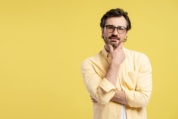 Fototapeta premium Pensive male entrepreneur strategizing, contemplating business decisions on yellow backdrop