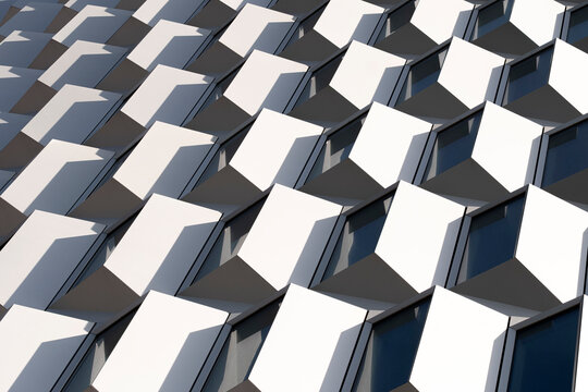 Sharp abstract perspective of white facade with cube texture and play of light and depth