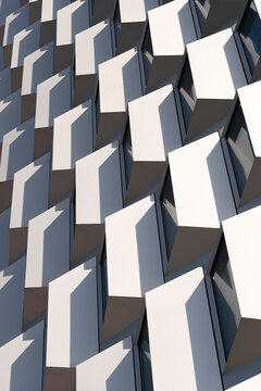 Facade pattern of white cubic modules with geometric repetition and strong light contrast