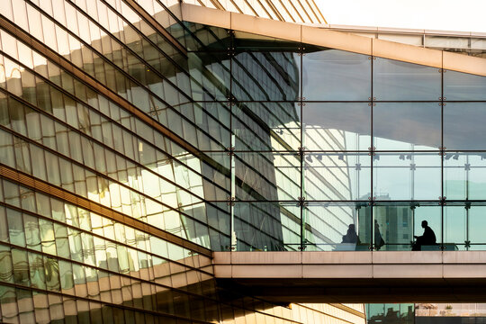 Golden glass facade with evening reflections and warm light geometry, modern structure with elegant symmetry and soft glow