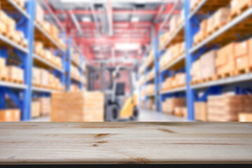 Empty wood table top with blur background of warehouse of factory. The table giving copy space for placing advertising product on the table