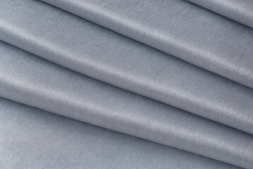 Abstract background made of natural gray fabric folded in several layers. Luxurious textile wallpaper