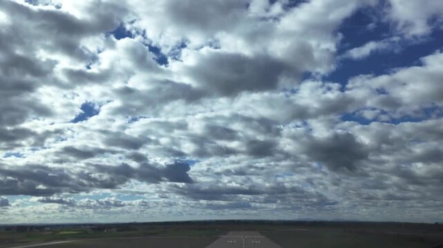 A pilot&rsquo;s viewof a real time take off as seen from inside the ccokpit of a jet airplane taking off from an isolated runway, under a deep blue sky with some cottony clouds. 4K