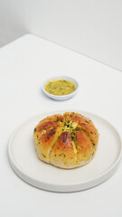 A close-up shot of freshly baked Korean cream cheese garlic bread, showcasing its soft, golden-brown exterior and the generous filling of creamy cheese and fragrant garlic butter.