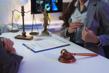 Businesswoman putting a wad of cash into her jacket pocket during a contract signing, suggesting...