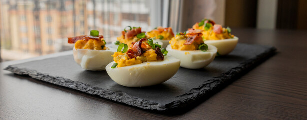  party appetizer featuring deviled eggs topped with crispy bacon and chopped green onions