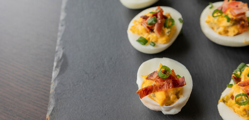  party appetizer featuring deviled eggs topped with crispy bacon and chopped green onions