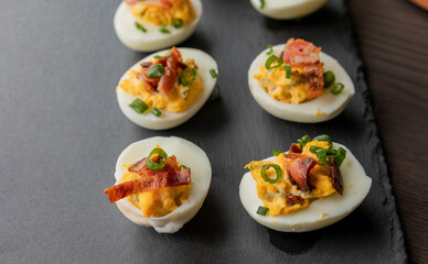  party appetizer featuring deviled eggs topped with crispy bacon and chopped green onions