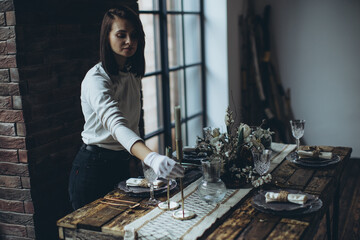 Table setting for the holiday. Table decor with soft candles and natural elements that create an...