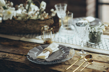 Table setting for the holiday. Table decor with soft candles and natural elements that create an attractive atmosphere. The process of decorating a dining table in a rustic style.