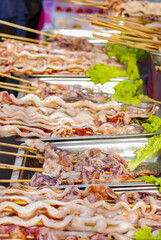 Seafood, raw squid before grilling placed on a white tray, Barbeque Grill Street Food Meat, vegetables and Chinese sausage.