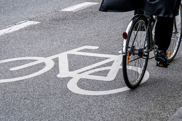 Bicycle lane with cyclist in motion on Copenhagen street, road marking and mobility concept in clean urban environment, dynamic angle with copy space.