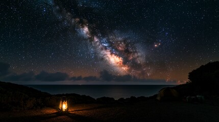 Fototapeta premium Starry night sky over ocean with lantern coastal landscape night photography serene atmosphere wide-angle view