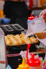 cooking takoyaki in a frying pan, Takoyaki is the most famous Japanese snack which is shaped into balls