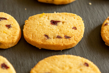freshly baked orange and cranberry cookies arranged on a dark background