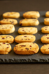 freshly baked orange and cranberry cookies arranged on a dark background