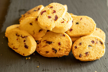 freshly baked orange and cranberry cookies arranged on a dark background