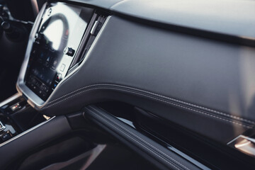 Modern black car interior, leather steering wheel, climate control, large navigation screen, air...