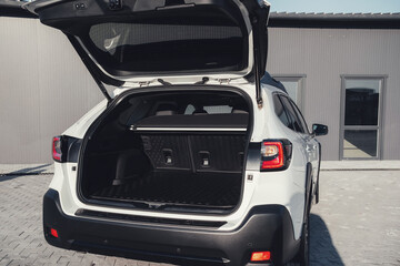 Modern black car interior, leather steering wheel, climate control, large navigation screen, air ducts, deflectors on the car panel. Interior details.
