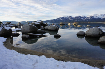 dusk setting at Sand Harbor, Lake Tahoe, California, USA with mirror reflection of the mountains in...