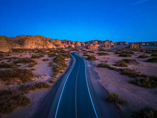 Fototapeta premium Aerial view of a road through the desert landscape at twilight. Famous Dahaidao no man's land natural scenery in Xinjiang, China.