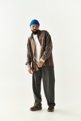 Stylish young man showcases unique fashion sense with modern flair in a minimalist setting