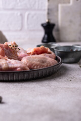 Raw chicken wings on black background.