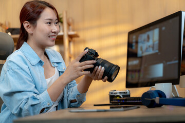 Naklejka premium A young freelance woman is happily editing a video at home