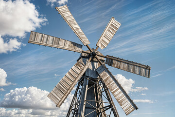 vintage light gray metal windmill stands tall in a rural landscape concept